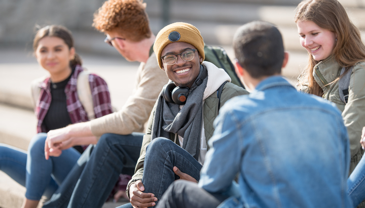 Students sat on steps outside university getting ready to play Treasure Hunt Glasgow