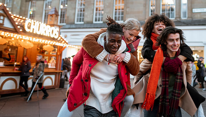 A group of friends walking away from a Christmas market on a treasure hunt