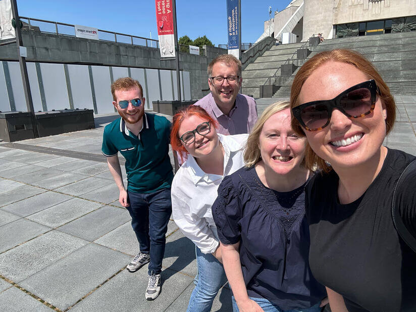 5 colleagues posing outside a catherdral playing a treasure hunt.